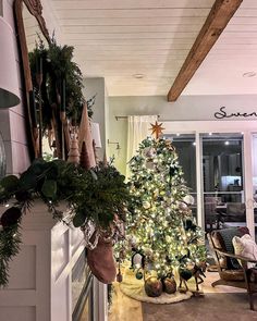 a decorated christmas tree sitting in the corner of a living room next to a fireplace