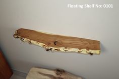 a piece of wood sitting on top of a wooden table next to a wall mounted shelf