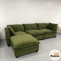 a large green couch sitting next to a white bed