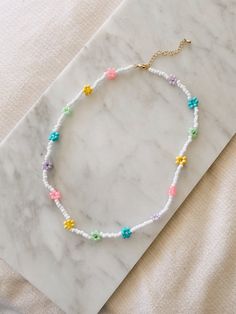 "This hand beaded flower necklace features rainbow or pastel flowers and measures 16\" at its smallest. Necklace is adjustable up to 18\" I love this necklace layered with other gold chains or worn alone to spruce up jeans and a t-shirt. Strung on elastic jewelry string and has a gold plated lobster clasp closure. Message me with any questions!" Spring Beaded Necklaces With Flower Charm And Round Beads, Adjustable Pastel Beaded Necklaces, Adjustable Colorful Beaded Necklaces For Spring, Adjustable Colorful Beaded Necklace For Spring, Spring Beaded Necklace With Flower Charm And Round Beads, Spring Gift Beaded Necklaces With Tiny Beads, Spring Beaded Necklace With Flower Charm, Spring Gift Beaded Necklace With Tiny Beads, Trendy Adjustable Flower Necklace With Colorful Beads