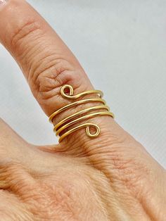 This lovely and stylish gold tone spiral statement ring makes a great gift! I have skillfully handmade this spiral ring with 18-gauge tarnish resistant gold tone wire. It is adjustable and looks great on.   If you would like this ring made with 14kt gold filled wire please message me. The price will be higher, and I will quote you a price before you buy it  All rights reserved: EdnasBeadBox and ArtByEdna on YouTube. Please follow me on social media. It really helps me because I take great care i Gold Spiral Bypass Ring As Gift, Adjustable Spiral Yellow Gold Ring, Adjustable Spiral Gold Midi Rings, Adjustable Gold Toe Bypass Ring, Adjustable Gold Bypass Ring Gift, Adjustable Gold Bypass Ring As Gift, Spiral Ring, Please Follow Me, 14kt Gold