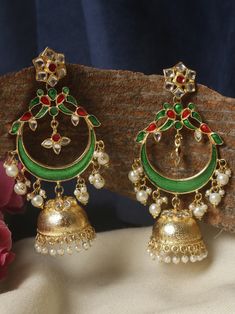 These  green and golden  long jhumkas are an exquisite accessory that exudes elegance and sophistication. Crafted with meticulous attention to detail, these earrings feature a mesmerizing combination of green and golden, creating a stunning contrast that catches the eye. The dark green pearls possess a deep, rich hue reminiscent of lush forests, adding a touch of intrigue and mystery to the overall design.  These earrings boast a long and slender design, gracefully cascading from the earlobes to create an alluring effect. The length adds a sense of drama and sophistication, making them perfect for formal occasions or adding a touch of elegance to everyday outfits. Whether you're attending a gala, a wedding, or a cocktail party, these long jhumkas are  sure to turn heads and elevate your st Green Latkan Bridal Earrings For Diwali, Green Latkans Bridal Earrings For Diwali, Green Bridal Earrings With Latkans For Diwali, Gold Cutdana Jhumkas For Eid, Gold Bollywood Jhumkas With Peacock Design, Green Chandbali Bridal Earrings With Latkans, Elegant Green Jhumkas With Zari Work, Festive Gold Chandbalis With Zari Work, Heavy Green Kundan Chandbalis