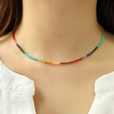 a woman wearing a multicolored beaded necklace on her left neck and chest