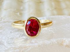 Formal Oval Cabochon Ruby Ring With Bezel Setting, Oval Ruby Solitaire Ring, Oval Ruby Ring For Anniversary, Classic Ruby Ring With Bezel Setting, Classic Oval Rings With Bezel Setting, Classic Oval Ring With Bezel Setting, Classic Red Oval Birthstone Ring, Classic Oval Red Birthstone Ring, Red Oval Rings With Bezel Setting