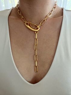 Chunky gold paperclip lariat featuring a large clasp. Necklace can clasp anywhere on the chain for different looks. Necklace is gold plated stainless steel. It is of great importance to me that I make jewelry for my customers that I, myself, wear every day. Each jewelry piece is handmade by me personally with love and care. Each item is crafted to the highest quality and made to exceed the expectations of my customers. My jewelry is designed to you to love and wear no matter what the occasion at Metal Lariat Necklace With Chunky Chain, Chunky Chain Metal Lariat Necklace, Chunky Chain Lariat Necklace, Gold Paperclip Necklace With Hooks And Links, Gold Chain Link Lariat Necklace, Everyday Gold Lariat Necklace With Lobster Clasp, Gold-tone Paperclip Chain Necklace, Elegant Chunky Chain Lariat Necklace, Chunky Chain Lariat Necklace As Gift