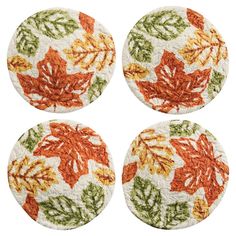 four coasters with orange and green leaves on them