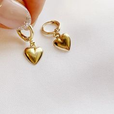 14k gold filled hearts dangle from huggie style hoops. Lightweight. Size: approx 1” 14k gold filled hoops Charms: 10mm Lever back closure Lead & nickel free / Hypoallergenic Handmade Includes 100% organic cotton jewelry pouch This item is made to order, packaged, and shipped with love from our studio located in West Chester, PA. *Click here to learn more about gold filled jewelry Hypoallergenic 14k Gold Filled Dangle Huggie Earrings, Gold Tarnish Resistant Huggie Earrings As Gift, Gold Tarnish Resistant Huggie Earrings For Gift, Gold Tarnish-resistant Huggie Earrings As A Gift, Gold Sterling Silver Huggie Earrings For Valentine's Day, Sterling Silver Heart Earrings Tarnish Resistant For Everyday, Gold Heart-shaped Huggie Earrings For Everyday, Trendy Small Hoop Heart Earrings As Gift, Trendy Heart-shaped Hoop Earrings For Gift