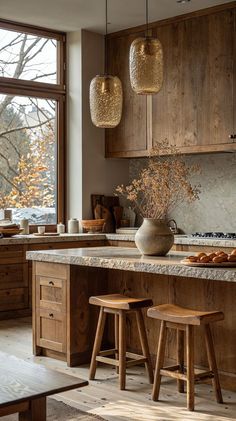 a kitchen with wooden cabinets and stools in front of a large window that looks out onto the woods