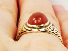 This Vintage 14k Carnelian Ring is wonderful! The yellow gold ring showcases a gorgeous orange colored carnelian cabachon stone. The setting has beautiful engraving on the sides of the band. The detail is lovely. The carnelian measures approximately 7 x 9 mm. The setting is marked 14k. This ring is in nice vintage condition and is ready to be worn and enjoyed. The carnelian has a rich look and coupled with the finely detailed setting creates a charming feminine look. This would make a wonderful Vintage Carnelian Yellow Gold Ring, Vintage Carnelian Signet Ring, Vintage Carnelian Hallmarked Ring, Vintage Polished Carnelian Jewelry, Antique Carnelian Cabochon Rings, Statement Rings Diamond, Diamond Bows, Carnelian Ring, Blue Stone Ring