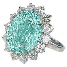 A stunning 11 carat Paraiba tourmaline displays its brilliant aqua color in this amazing ring. Paraiba tourmalines are among the most valuable gemstones in the world, and this stone exhibits the signature neon green color seen only in the finest specimens. An additional 2 carats of round brilliant-cut diamonds surround the jewels and travel down the entire band of this hand-crafted 18 carats white gold mounting. These stones owe their spectacular coloring to the presence of copper in the stone. Paraiba Tourmaline Ring, Pear Cut Diamond Ring, Brilliant Cut Diamond Ring, Blue Topaz Engagement Ring, Fantasy Gifts, Diamond Cocktail Ring, Topaz Engagement Ring, Paraiba Tourmaline, Engagement Ring Diamond Cut