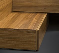 a close up of a wooden drawer on a black surface with no one around it