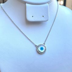 Sterling Silver Evil Eye Necklace, Protection Necklace, Good Luck Pendant Necklace, Minimalist Necklace, Christmas Gift, Layered Necklace Featuring a perfect round evil eye gem surrounded with a circle of shimmering cubic zirconia stones on the side, this piece of sterling silver necklace is suitable for causal wear and it will definitely earn you a lot of compliments for being so special and sweet. Metal Details Metal:.925 Sterling Silver Style: Pendant Finish: Rhodium Plated Chain: Rolo Chain Evil Eye Round Pendant Necklace Gift, Round Evil Eye Jewelry Gift, Evil Eye Round Jewelry Gift, Minimalist Round Evil Eye Jewelry, Silver Evil Eye Round Pendant Necklace, Silver Necklace With Evil Eye Round Pendant, Sterling Silver Evil Eye Charm Necklace, White Evil Eye Round Pendant Necklace, White Round Pendant Necklace With Evil Eye