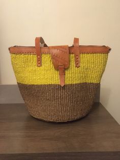 a yellow and brown basket sitting on top of a wooden table