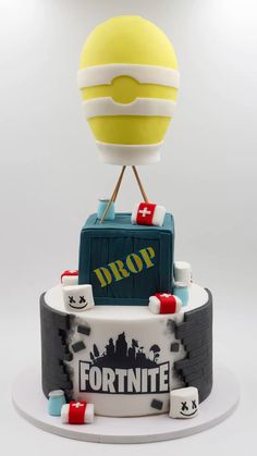 a cake made to look like a hot air balloon on top of a fortnite box