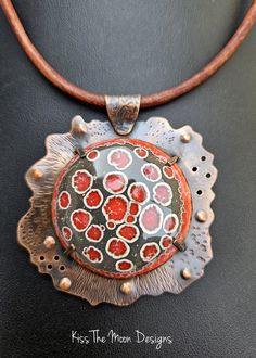 Discover the Unique Charm of Our Large Crackle Enamel and Copper Necklace Elevate your accessory game with the Large Crackle Enamel and Copper Necklace in stunning shades of grey and red. Each necklace is a masterpiece, crafted through a meticulous process of fusing powdered glass to copper, resulting in a pendant that is not only beautiful but also truly one of a kind. Key Features: Unique Design: Each pendant develops its own unique patterns during the firing process, making your necklace an e Red Enamel Round Necklace, Handmade Enamel Round Necklace, Handmade Round Enamel Necklace, Handmade Round Enamel Necklaces, Handmade Enamel Round Necklaces, Artisan Hand Painted Metal Jewelry, Artisan Rust-colored Metal Jewelry, Red Enamel Round Pendant Necklace, Artisan Red Necklace With Round Pendant