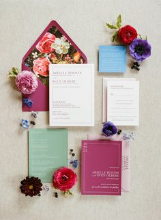 the wedding stationery is laid out with flowers