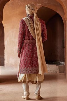 Red full sleeve sherwani, highlighted with all over peacock feather motif embroidery. Paired with a beige monga tussar kalidar kurta and churidar.
Components: 3
Pattern: Embroidery
Type Of Work: Peacock, Thread, Zardozi
Neckline: Stand Collar
Sleeve Type: Full Sleeves
Fabric: Matka Silk and Monga Tussar
Color: Red
Other Details: 
Model height: 6ft, wearing size M
Note: The belt, shawl, footwear and safa worn  by the model is not for sale
Occasion: Destination Wedding,Groom - Aza Fashions Traditional Anarkali Set With Naqshi And Traditional Drape, Traditional Naqshi Anarkali Set For Ceremonies, Traditional Anarkali Set With Naqshi For Ceremonies, Ceremonial Anarkali Sherwani In Raw Silk, Long Sleeve Naqshi Traditional Wear In Raw Silk, Anarkali Style Ceremonial Sherwani In Raw Silk, Traditional Anarkali Set With Naqshi For Diwali, Traditional Draped Jamawar Wear With Naqshi Details, Traditional Jamawar Wear With Naqshi Drape