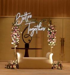 a sign that says better together with flowers on the front and back of two chairs