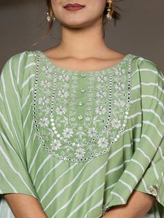 This 2-piece set includes green embroidery & leheriya print kaftan style kurta has round neck, short flared sleeves, flared hem, calf length teamed with solid trouser pants with elasticated waistband & slip on closure. 2 Piece Set Color-Green Kurta Fabric- Silk Blend Work - Thread Work Embroidery & Leheriya Print Detailing Neck - Round Neck Sleeves - Short Flared Sleeves Length-Calf Length Pocket - Single Pocket Bottom - Solid Trouser Pants Size & Fit - Elasticated Waistband Bottom - Slip-on Closure Washing Care-Hand Wash The model height 5'8 is wearing a size small Green Traditional Wear With Gota Work For Spring, Spring Green Traditional Wear With Gota Work, Spring Green Embroidered Palazzo Set, Spring Anarkali Set With Mirror Work And Straight Kurta, Spring Salwar Kameez With Gota Work And Long Sleeves, Spring Cotton Traditional Wear With Mirror Work, Green Palazzo Set With Dabka Work For Spring, Bollywood Style Kurta With Gota Work For Spring, Spring Pista Green Kurta With Mirror Work