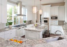 a large kitchen with white cabinets and granite counter tops, along with an island in the middle