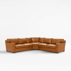 a brown leather sectional sofa on a white background