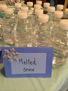 a table topped with lots of water bottles and snowflakes on top of it