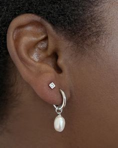 Classy and chic, we’re obsessed with the Willa Gold Pearl Huggie Earrings in White Pearl—and you will be, too! A dainty cultured freshwater pearl dangles from a petite huggie for a lightweight style you’ll pair back with any stack. Metal 14k Gold Over Brass Material White Pearl Closure Ear Post Size 1.8" Outside Diameter, 0.4"L X 0.3"W CharmDue to the one-of-a-kind nature of the medium, exact colors and patterns may vary slightly from the image shown. | Kendra Scott Willa Gold Huggie Earrings in White | Pearl Silver Earrings Classy, Classy Stud Earrings, Double Piercing Earrings Studs, Pearl Earrings Dangle Silver, Simple Wedding Earrings Silver, Earring Combos Double, Silver Dainty Earrings, Silver Dangle Pearl Earrings, Silver Earring Stack 3 Holes