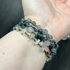 This incredible wrap bracelet has been a work in progress for a while. The combination of the pewter focal with the gorgeous 6mm flashy labradorite rounds absolutely enchanted me. From there, I added so many of my favorite things. In this bracelet, you’ll find apatite rectangles, the most insane faceted 8mm kyanite, 8mm starcut pale jade, flashy tourmilinated rainbow moonstone, smoky quartz, and the most incredible faceted prasiolite nuggets. Also featured are the prettiest faceted glass rondelles. Let’s circle back to the focal. The shape was so interesting and mysterious to me. I wrapped on faceted labradorite and iolite to bring out some of the lines. This wrap bracelet is sterling silver, with the exception of the USA made pewter focal. The knotted portion of the bracelet was done in h Hand-wrapped Labradorite Round Beads Jewelry, Hand Wrapped Labradorite Bead Jewelry, Silver Multi-strand Hand Wrapped Bracelets, Silver Multi-strand Spiritual Bracelets, Silver Wrap Bracelet With Gemstone Beads, Spiritual Silver Multi-strand Bracelets, Spiritual Multi-strand Silver Bracelets, Spiritual Silver Hand-strung Wrap Bracelet, Silver Multi-strand Bracelet With Natural Stones