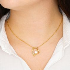 a woman wearing a gold heart necklace