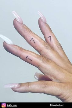 a woman's hand with two finger tattoos on it