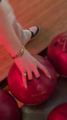 a close up of a person's hand on some bowling balls