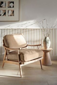 a wooden chair sitting next to a vase filled with flowers