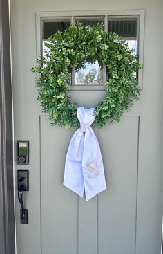 a wreath with the letter s hanging on a door