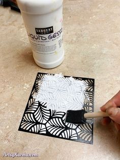 someone using a brush to paint the design on a piece of art paper with glue