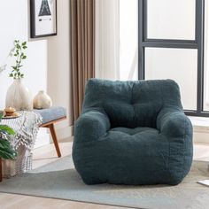 a blue bean bag chair sitting on top of a wooden floor next to a window