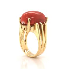 This beautiful Mid-Century cocktail ring features a cabochon cut red coral in 18 karat yellow gold. The coral has a medium scarlet red hue and is set in four golden prongs. The shoulders of the tapered band feature streamlined, openwork spaces for a bit of skin to peek through. From the profile, the Mid-Century details of the ring can truly be admired. The ring has a strong architecture and distinct style, finished in high polish 18k yellow gold. Formal Open Ring With Unique Design, Modern Oval Opal Ring For Formal Occasions, Luxury Formal Ring With Unique Design, Luxury Formal Rings With Unique Design, Unique Formal Rings With Polished Finish, Unique Hallmarked Ruby Ring For Formal Occasions, Luxury Rings With Unique Design For Formal Occasions, Luxury Cabochon Signet Ring For Formal Occasions, Luxury Red Rings For Formal Occasions