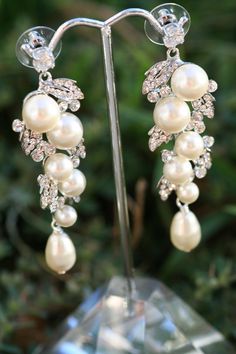 "Simply Chic.These earrings will sure make a big statment on your wedding day. Trinkling pearls surrounded with crystal petals and finished with a pear shape swarovski pearls .They are about 2 1/2 \" long. Matching bracelet available at this link https://www.etsy.com/listing/270957298/petals-and-leaves-rhinestone-crystal?ref=shop_home_active_1" Wedding Cuff Bracelet, Wedding Earrings Chandelier, Pearl Bracelet Wedding, Vintage Wedding Jewelry, Wedding Earring, Pearl Bridal Jewelry, Bridal Earrings Drop, Pearl Earrings Wedding, Bridal Earrings Pearl