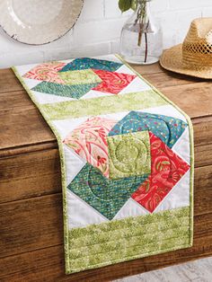 a quilted table runner on top of a wooden dresser