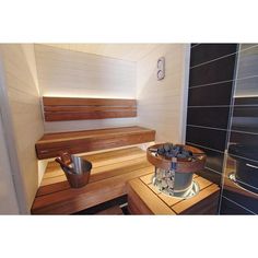 a wooden bench sitting in the middle of a room next to a shower and sink