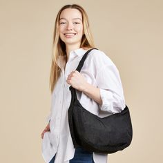 This effortlessly casual Baggu Crescent Bag is large enough to carry a bit more than just your daily essentials, making it a versatile go-to accessory. Made from durable 100% heavyweight nylon (59% recycled), this bag can be worn slung over your shoulder or crossbody for a hands-free experience. It features two interior pockets which make organizing your belongings easy. The Baggu Crescent Bag measures 8h x 13.75w x 4�d. The adjustable tonal logo strap is 37.5 at its maximum length. Machine wash Casual Nylon Hobo Bag For On-the-go, Reusable Nylon Bags For Everyday Use, Everyday Reusable Nylon Bags, Casual Nylon Hobo Bag For Travel, Versatile Packable Black Shoulder Bag, Versatile Black Packable Shoulder Bag, Everyday Large Capacity Nylon Hobo Bag, Lightweight Nylon Shoulder Bag For Everyday Use, Functional Reusable Everyday Bags