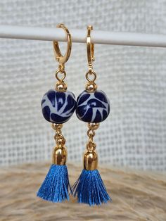 We combine art and elegance to create this beautiful piece. Our handmade earrings will be the perfect element to make your outfit standout. You could have the entire collection or gift them to someone special.  Material: Real Gold plate brass, Talavera gemstone  Dimensions: Drop Length 5cm, weight 2g Features : Lightweight, Unique and Simple design The Talavera of Puebla is part of the intangible heritage of humanity, declared by UNESCO. It is a type of majolica ceramic with a mixture of Chinese, Italian, Spanish, and indigenous techniques, and its colors are obtained from natural pigments. Its main characteristics are its vitreous finish and the use of bulky cobalt blue, this made it even more exclusive and ostentatious than Spanish craftsmanship. Its production requires at least 120 hour Blue Beaded Brass Earrings As Gift, Gift Blue Beaded Brass Earrings, Handmade Gold Beaded Drop Earrings, Blue Handmade Danglers For Festive Occasions, Handmade Blue Drop Earrings, Elegant Handmade Festive Hoop Earrings, Artistic Handmade Jewelry For Festive Occasions, Blue Danglers With Latkans For Gift, Blue Latkans Danglers Gift