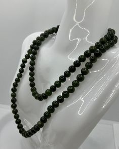 Discover the exquisite Vintage Jade Necklace, a true gem for lovers of high-quality jewelry. With an impressive length of 80 cm and a pearl diameter of 0.7 cm, this necklace offers a remarkable presence. Each of the jade pearls radiates a deep, rich green color that adds a touch of sophistication to any outfit. The necklace weighs a total of 83.26 grams and impresses with its high-quality workmanship and timeless design. This necklace has a practical twist clasp that ensures a secure hold and is Elegant Jade Beads As Gift, Long Jade Gemstone Bead Necklace, Long Jade Necklace With Gemstone Beads, Elegant Jade Necklaces With Round Beads, Elegant Round Jade Beaded Necklaces, Elegant Jade Gemstone Beads, Formal Green Pearl Necklace With Round Beads, Classic Jade Necklaces With Round Beads, Classic Jade Necklace With Round Beads