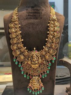 an elaborate necklace is displayed on a mannequin in front of a display case