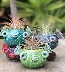 four ceramic fish planters sitting on top of a wooden table