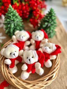 small white teddy bears sitting in a wicker basket on a table next to christmas decorations