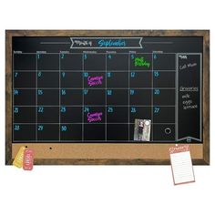 a chalkboard with magnets and notes on it next to a notepad that says calendar