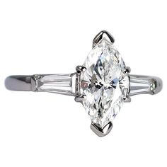 an oval cut diamond ring with baguetts on the shoulders