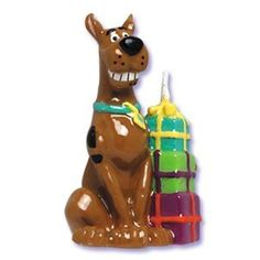 a brown dog sitting next to a stack of blocks with a candle in it's mouth