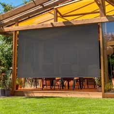 an outdoor covered patio with table and chairs under a yellow awning in the shade