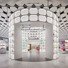 the inside of a retail store with white walls and circular lights hanging from the ceiling